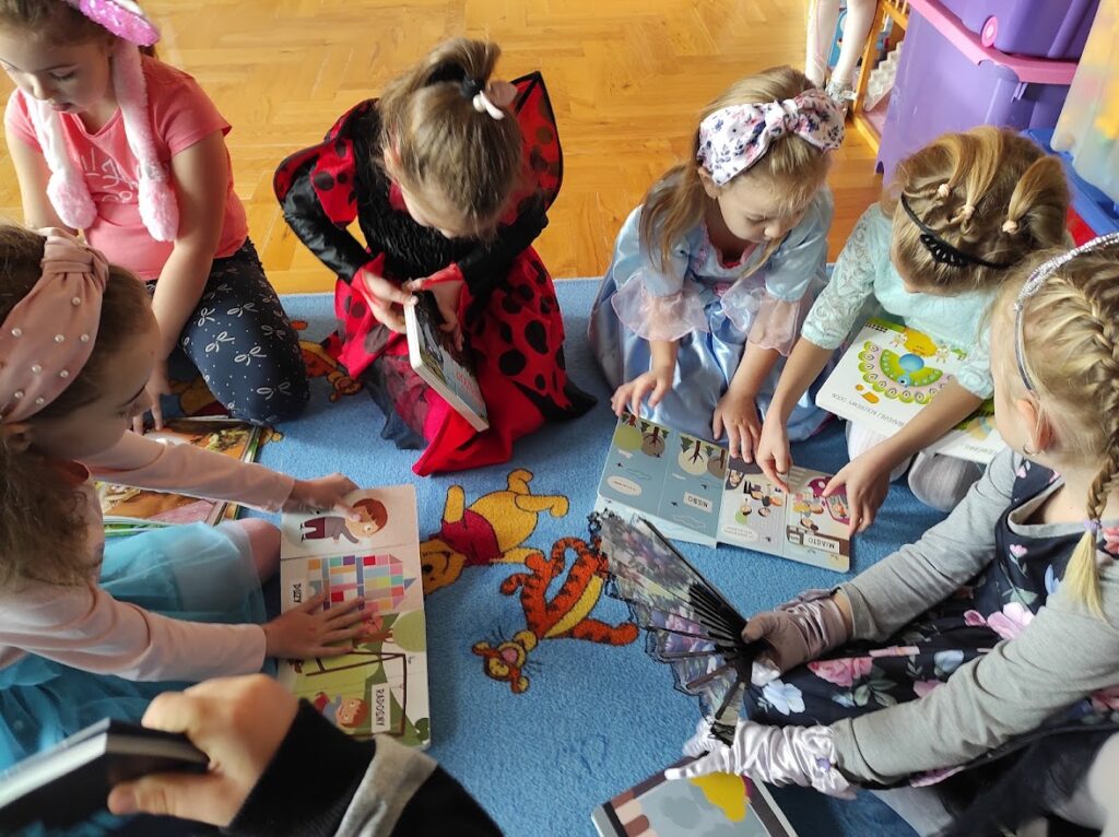 grupa dzieci czyta bajki
