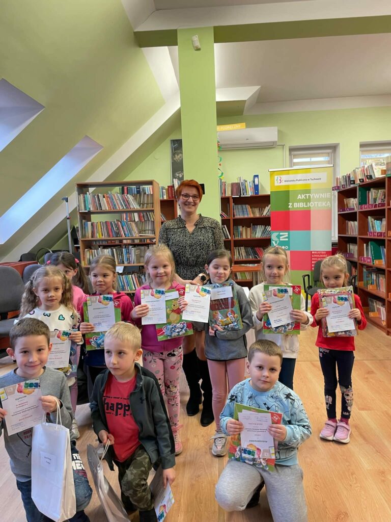 grupa dzieci z dyplomami w bibliotece