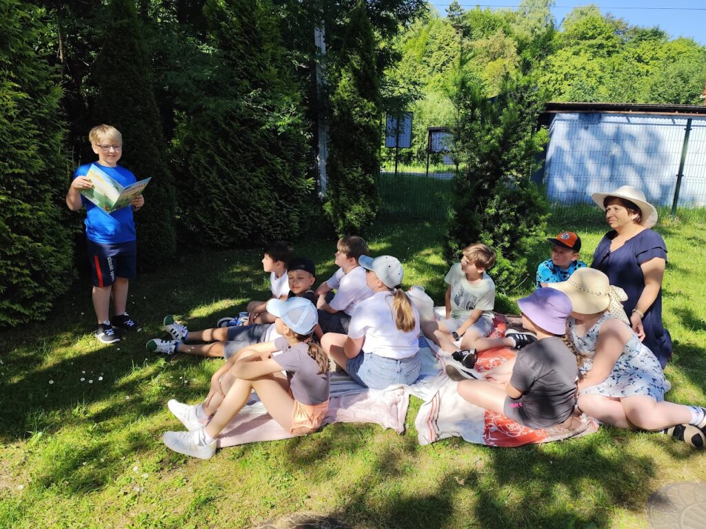 dzieci siedzące na kocyku