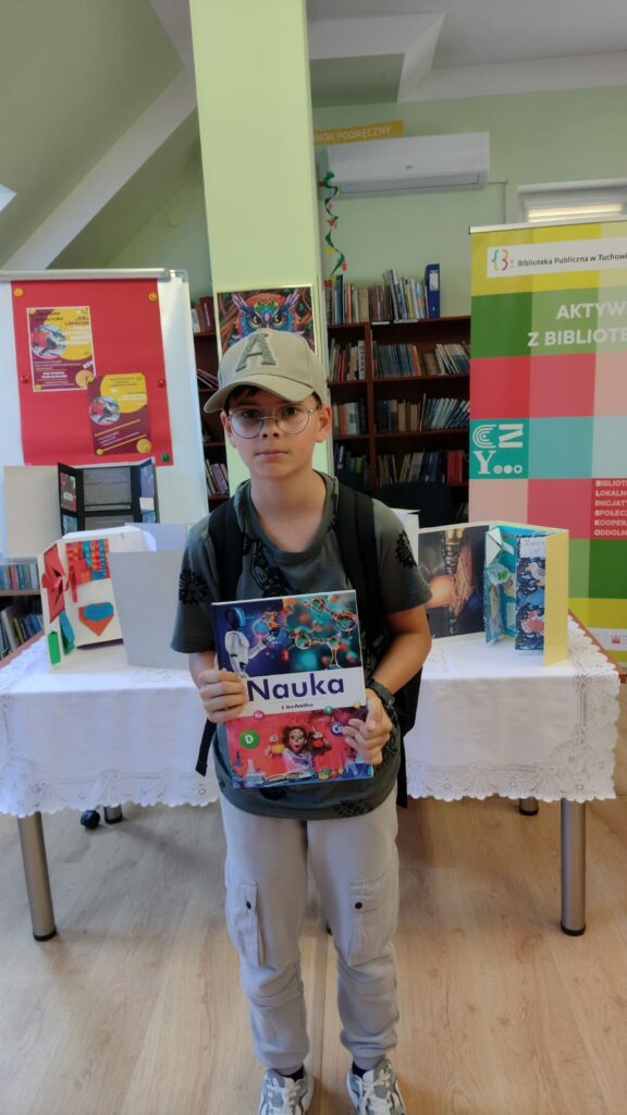 chłopiec z nagrodą w bibliotece