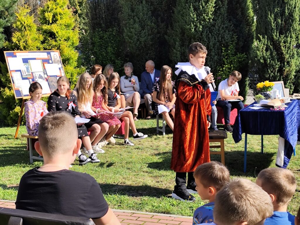 Grupa osób w plenerze podczas narodowego czytania