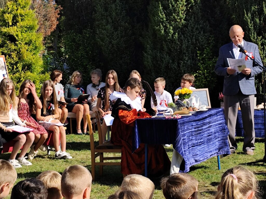 Grupa osób w plenerze podczas narodowego czytania