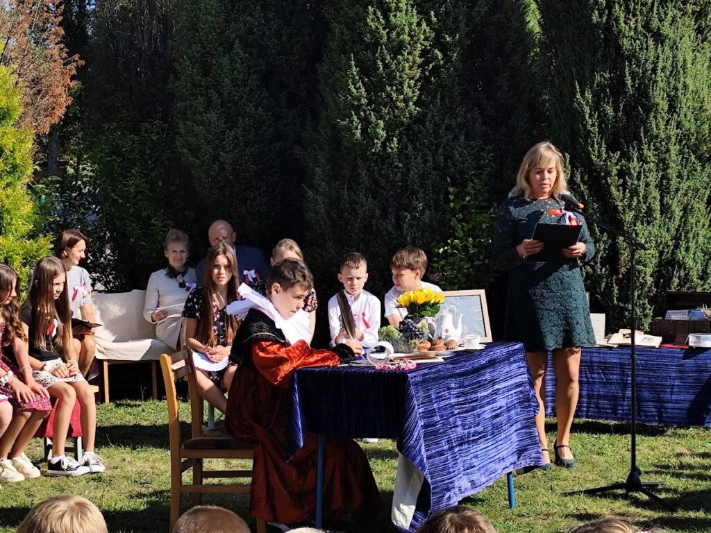 Grupa osób w plenerze podczas narodowego czytania