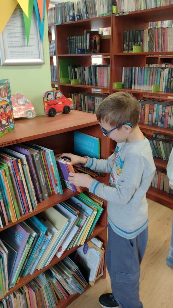 chłopiec przy regale z ksiązkami