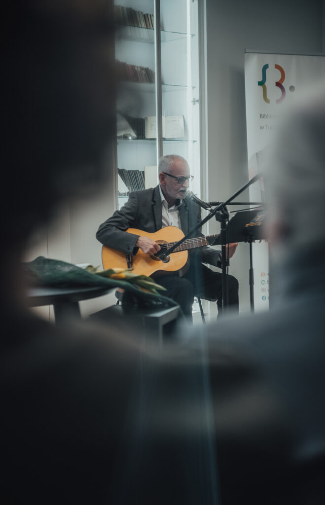 człowiek grający na gitarze