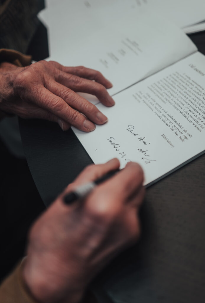 dłonie podpisujące książke