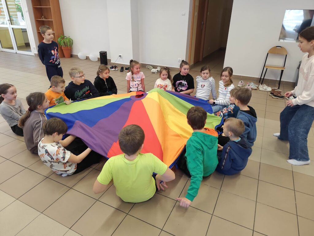 grupa dzieci podczas zabawy z chustą