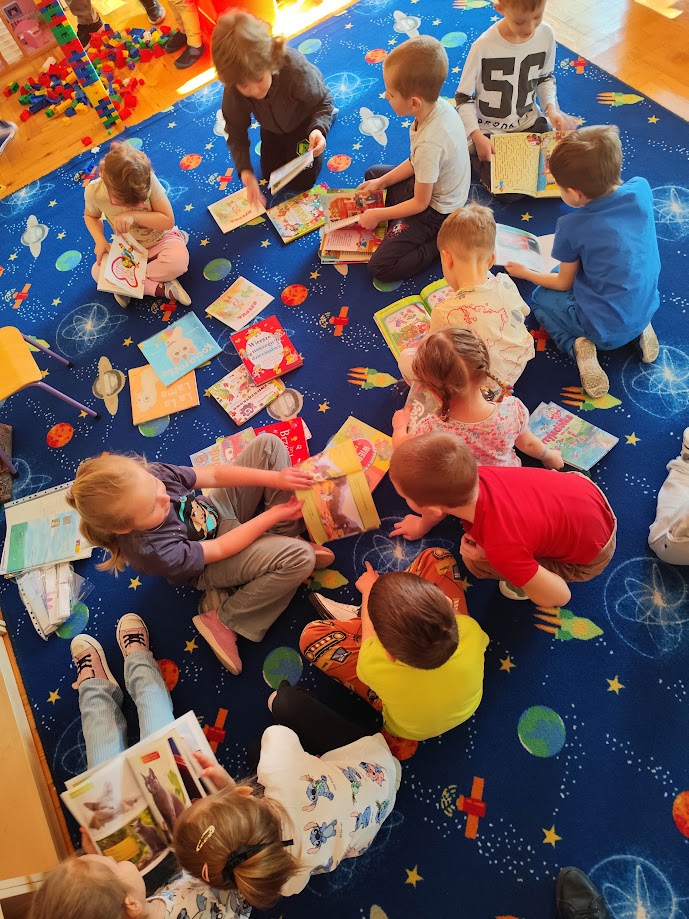 grupa dzieci siedząca na dywanie