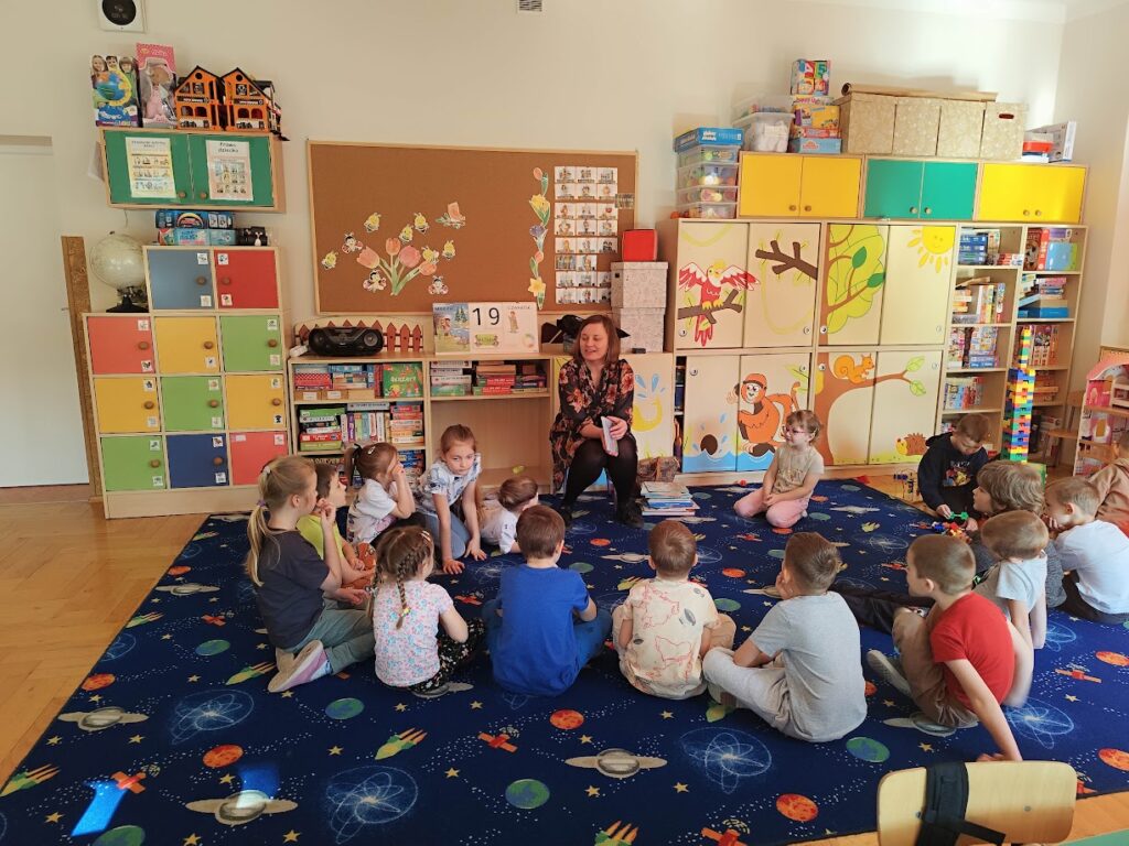 grupa dzieci siedząca na dywanie