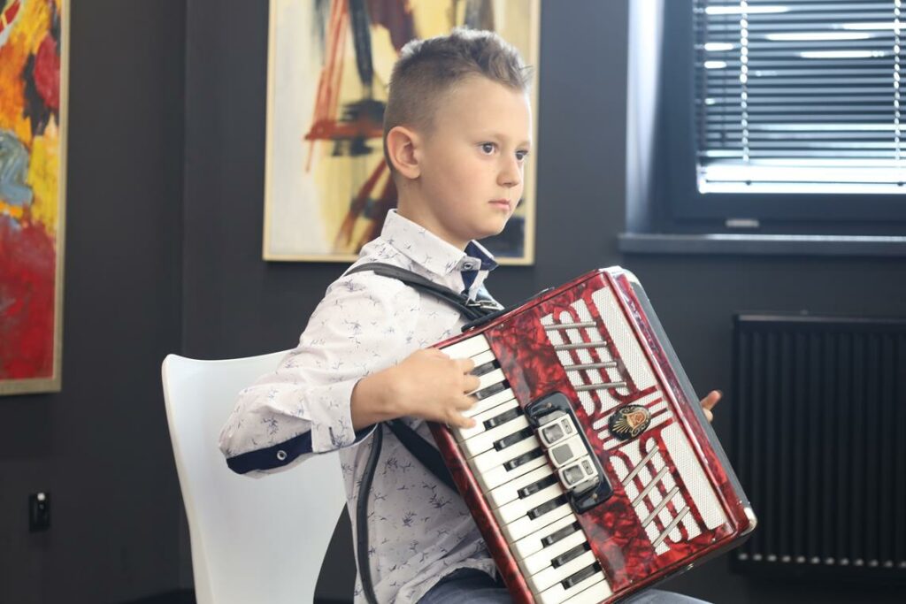 chłopiec grający na akordeonie