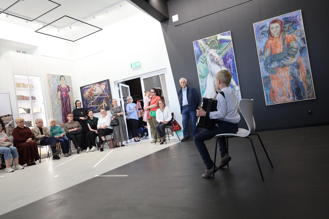 grupa osób na wernisażu malarskim