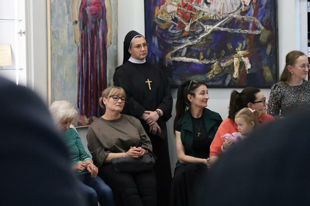 grupa osób na wernisażu malarskim