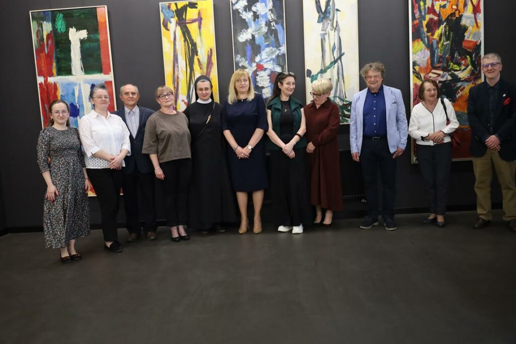 grupa osób na tle obrazów w  galerii