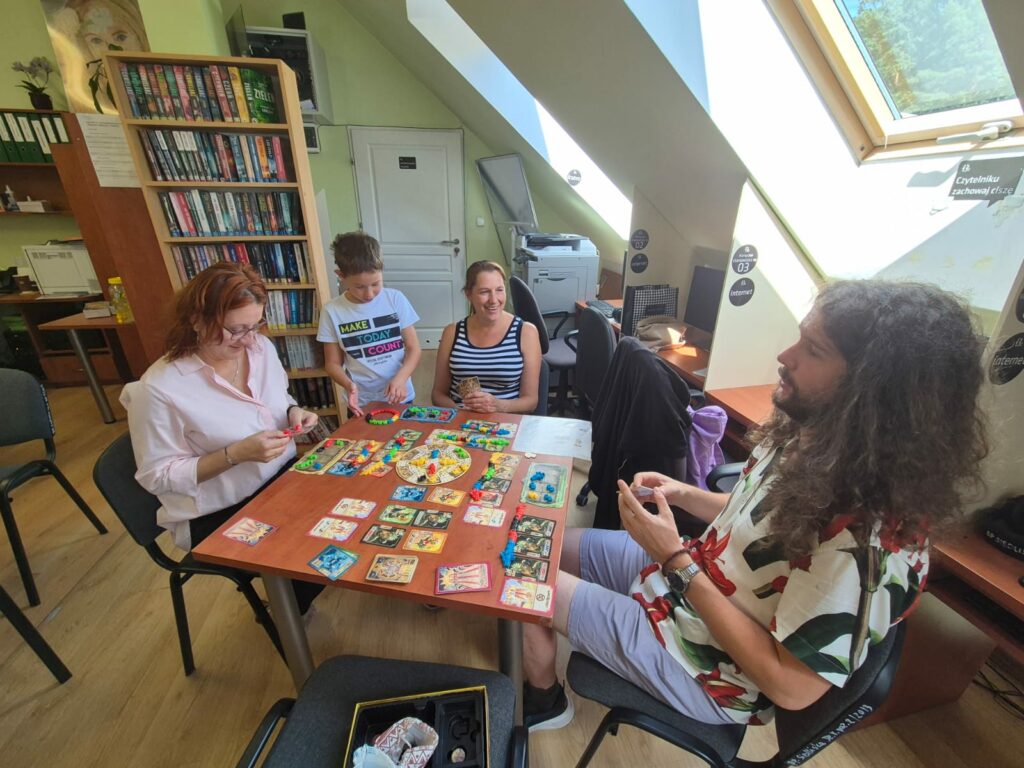 kilka osób w bibliotece gra w planszówki