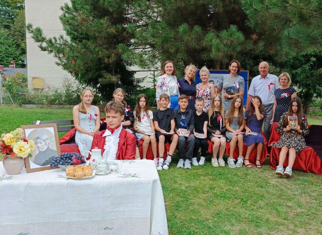 grupa osób czyta w plenerze