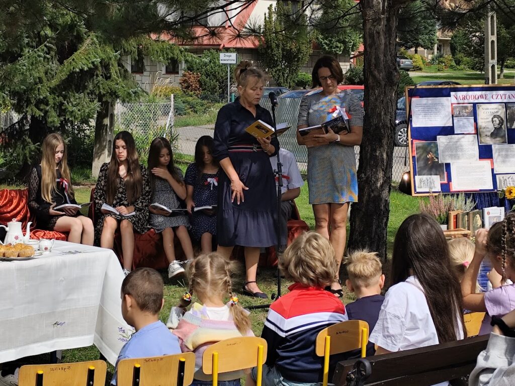 grupa osób czyta w plenerze