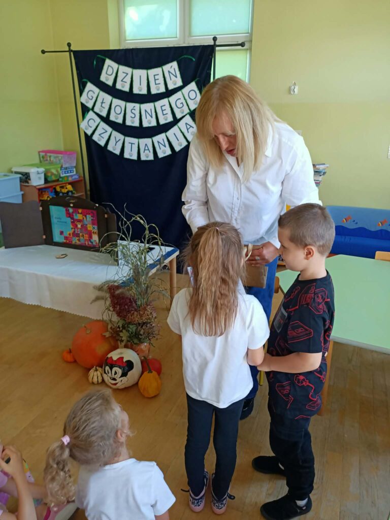 dzieci wręczają prezent prowadzącej spotkanie